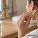 Person applying roll-on behind ear for stress relief and relaxation