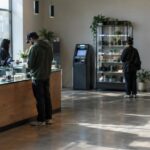 Cannabis dispensary lobby with customers and an unbranded ATM machine