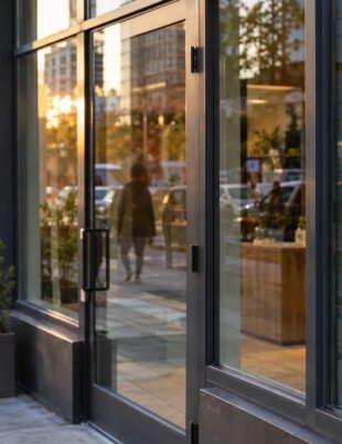 Urban cannabis dispensary storefront with adult looking on in late afternoon light