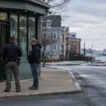 Exterior of Portsmouth cannabis dispensary with federal agents nearby in overcast light