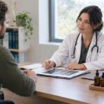 Doctor consulting patient with medical cannabis products on desk in clinic
