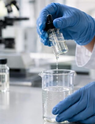 Scientist handling CBD nanoemulsion solution in laboratory setting