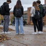 Teenagers standing outside a school in autumn, suggesting youth and cannabis risk